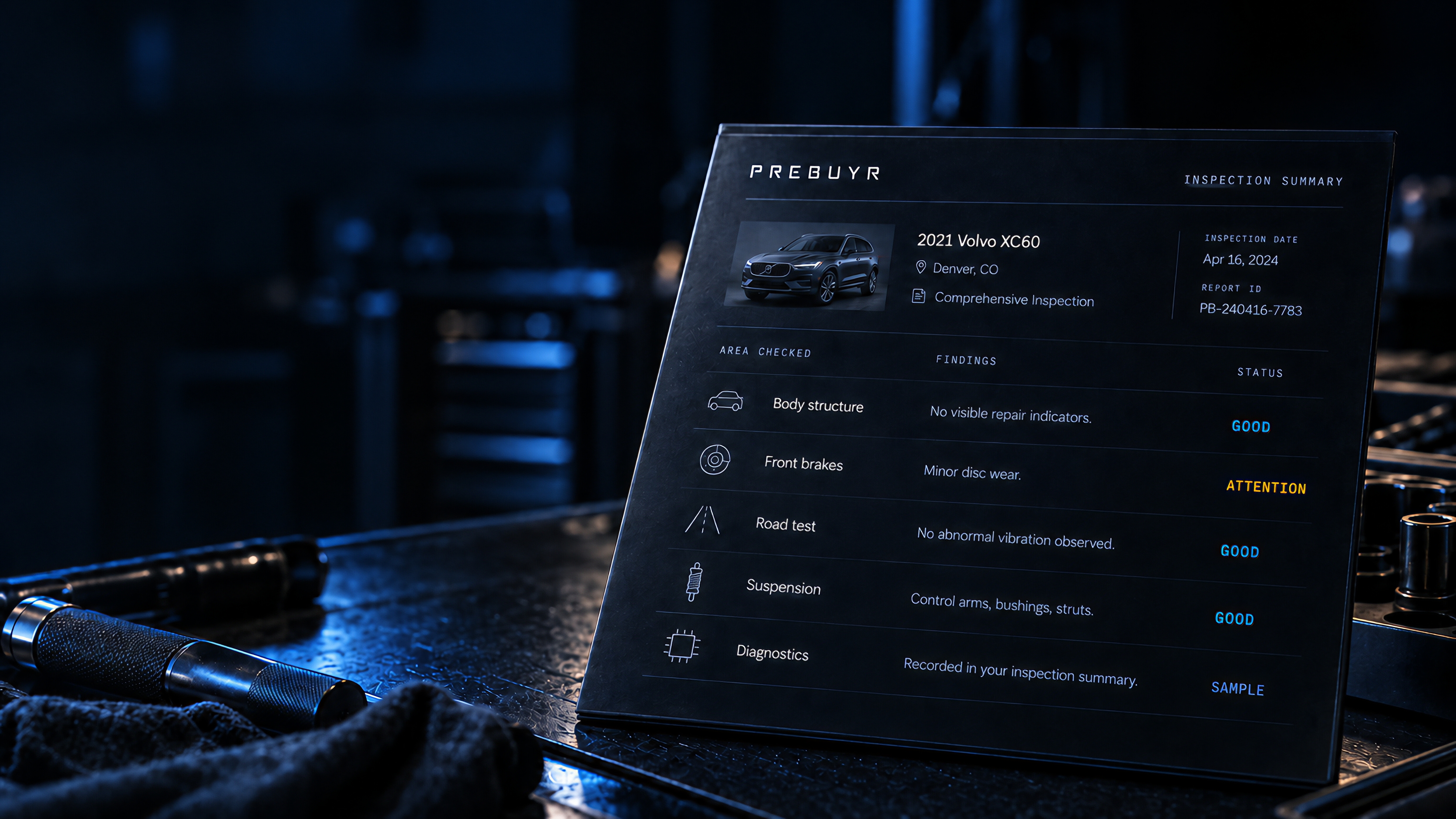Illustrative PREBUYR sample inspection report on a workshop bench, showing vehicle information and example findings.